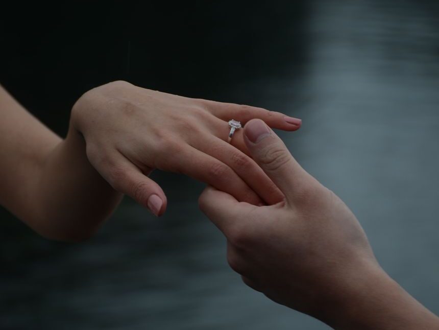 romantic engagement ring exchange near water